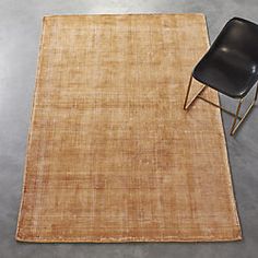 a chair sitting on top of a rug next to a black chair and a table