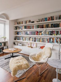 a living room filled with furniture and bookshelves covered in lots of bookcases