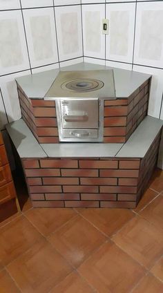 an oven built into the side of a brick wall in a room with tile flooring