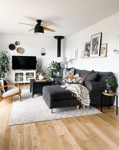 a living room filled with furniture and a flat screen tv on top of a wooden floor