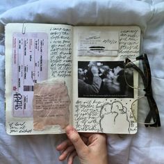 an open book with writing on it and glasses laying on top of each other next to a pair of eyeglasses