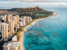 an aerial view of the city and beach in hawaii, with mountains in the background