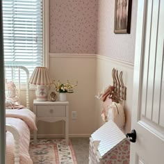 a bedroom with pink and white decor in the corner next to a bed, dresser and window