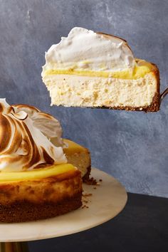 a piece of cheesecake being lifted by a fork from a cake dish on a plate