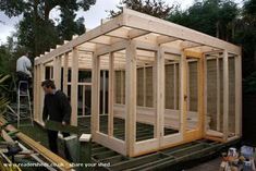 two men working on building a wooden house