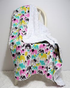 an elephant print blanket on top of a white chair