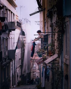 an alleyway with clothes hanging out to dry on the line and buildings in the background