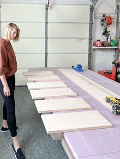 a woman standing in front of a table with wood planks on top of it