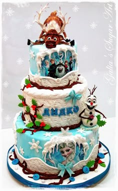 a three tiered cake decorated with frosting and frozen animals on top, surrounded by snowflakes