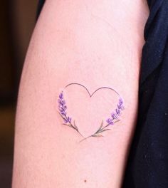 a woman's arm with a heart shaped lavender tattoo on it