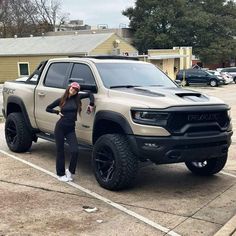 a woman standing next to a truck in a parking lot