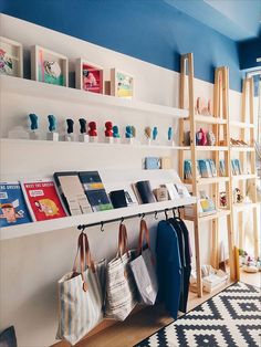 there are many bags and purses on the shelves in this room, along with bookshelves