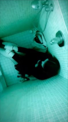 a person laying on the floor in a bathtub with their feet up and head down