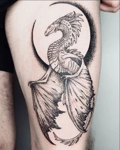 a black and white photo of a dragon sitting on the back of a man's thigh