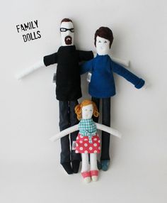 three dolls sitting on top of each other in front of a white background with one doll standing between two people