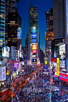 a city street filled with lots of traffic and tall buildings in the night time sky