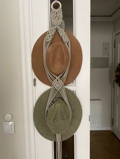 three hats are hanging on the wall in front of a door with a hat rack attached to it