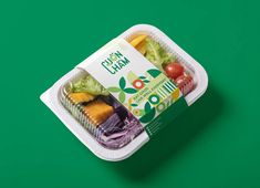 a plastic container filled with lots of different types of food on top of a green surface