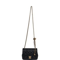 This Chanel Mini Square Pearl Crush Flap Bag is of black lambskin leather with antique gold hardware. It has a front flap with signature CC turnlock closure, tonal stitching, rear half moon pocket, a single interwoven black leather and antique gold tone chain link shoulder/crossbody strap and faux pearl top handle strap. The interior is lined in gold leather and features a zipper pocket with Chanel pull and an open pocket below.Collection: 24POrigin: ItalyCondition: New and never worn (plastic o Mini Black Bag, Chanel Pearl Crush, Black Sling Bag, Chanel Mini Square, Pearl Top, Chanel Pearl, Chanel Box, Chanel Pearls, Chanel Mini