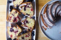 slices of blueberry pound cake with icing and fresh berries on the plate next to it