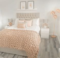 a bedroom with a bed, nightstands and pictures on the wall