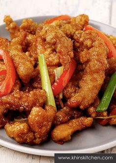 a plate full of fried chicken with peppers and celery on the side for garnish