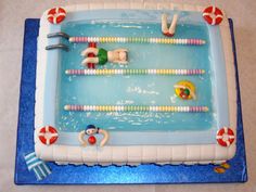 a cake shaped like a swimming pool with people in the water and life vests on