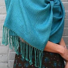 a woman wearing a blue shawl with tassels