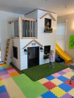 a child standing in front of a house shaped like a doghouse with a slide