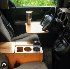 the interior of a vehicle with two cups and a cup holder