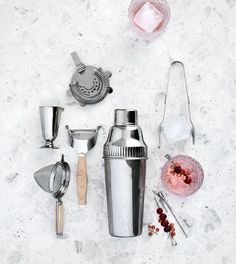 various kitchen utensils and mixers on a white counter top with ice cubes