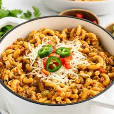 a white bowl filled with chili macaroni and cheese on top of a table