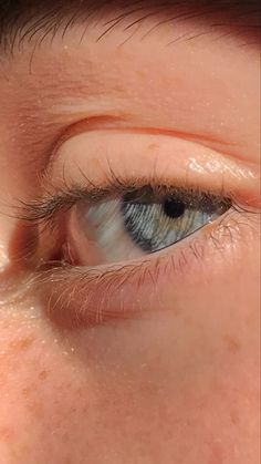 a close up view of an eye with blue eyes