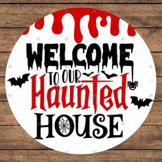 a sign that says welcome to our haunted house on a wooden background with bats and spider webs