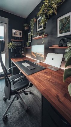 a desk with a laptop computer on top of it next to a window and potted plants