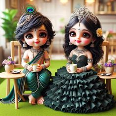 two dolls sitting next to each other on a table