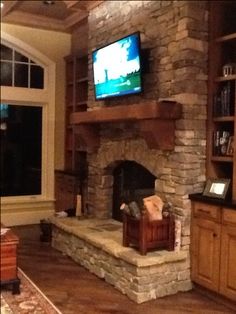 a living room with a stone fireplace and entertainment center