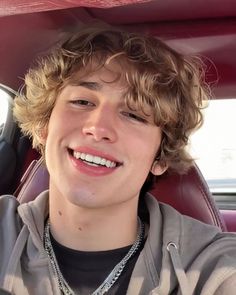 a young man sitting in the back seat of a car with his head turned to the side