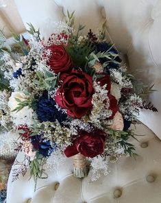 a bouquet of red, white and blue flowers sitting on top of a chair in a room