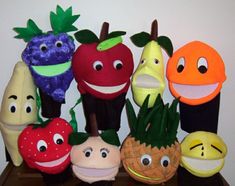 a group of stuffed fruits and vegetables sitting on top of a wooden table next to each other