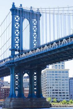 a large blue bridge spanning the width of a city