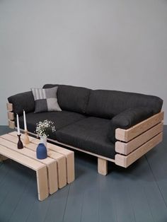 a living room with a black couch and coffee table next to it on hard wood flooring