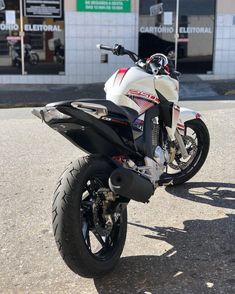 a white and red motorcycle parked in front of a building