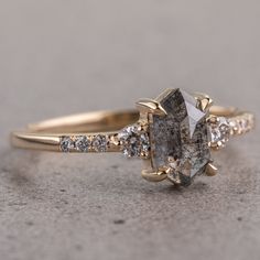 a close up of a ring with a stone in the middle and diamonds around it