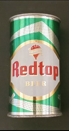 a can of redtop beer sitting on top of a black table next to a wall