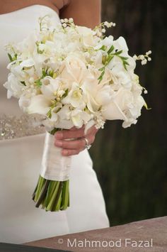 a bride holding a bouquet of white flowers