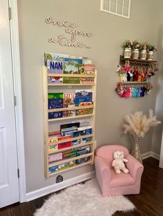 a pink chair sitting in front of a bookshelf filled with children's books