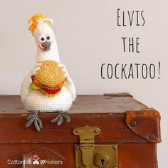 a stuffed chicken sitting on top of an old suitcase with the caption elviss the cockatoo