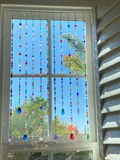 a window with beads hanging from it's side and palm trees in the background