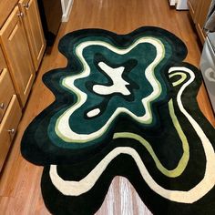 a kitchen area rug with an abstract design on the floor and cabinets in the background